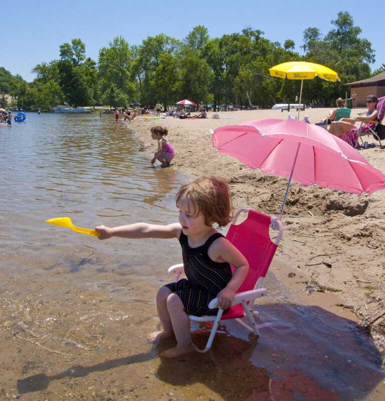 Children swim and play at Hamlin Lake Beach in Ludington State Park